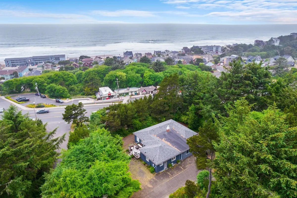 A serene panorama featuring ocean views, surrounding greenery, a roadway, and nearby houses. The scene invites thoughts of beach outings, nature walks, and community exploration, with an emphasis on tranquility and accessibility.