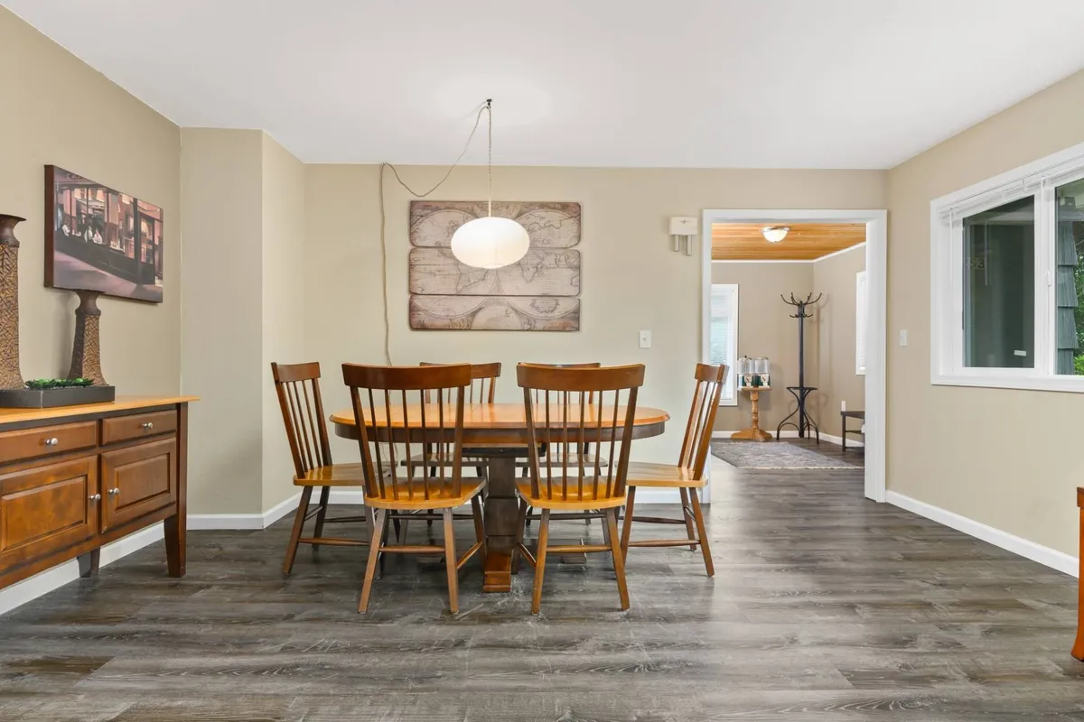 A warm dining area featuring a wooden dining table, a thoughtful seating arrangement, decorative wall art, and a sideboard. The scene suggests cozy family dinners, social gatherings, and communal celebrations, tying the kitchen seamlessly to the adjacent dining experience.